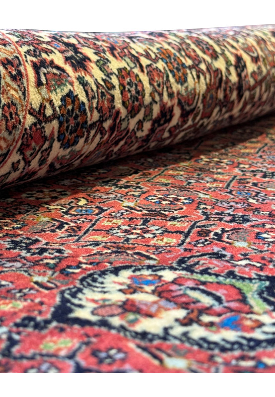 Part of a rolled Persian Bidjar rug (Iron Rug), highlighting the rug's thickness and the vibrancy of its outer patterns.