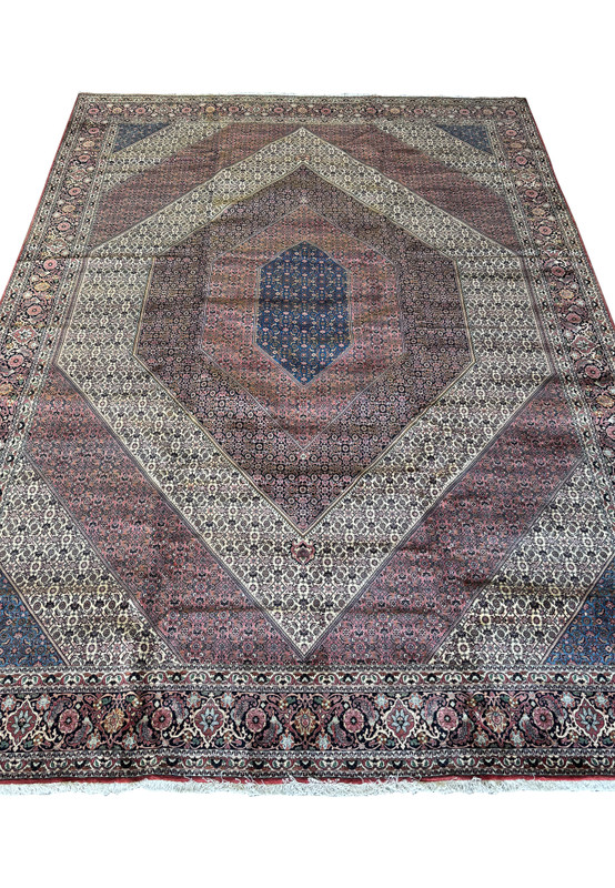 Close-up view centering on the intricate central design of a Persian Bijar rug, with a stark contrast of patterns and hues.