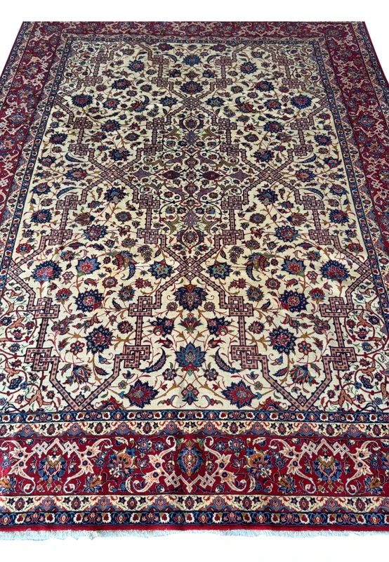 Close-up of the central field of the Persian Isfahan rug with detailed floral designs and geometric shapes on an ivory background.