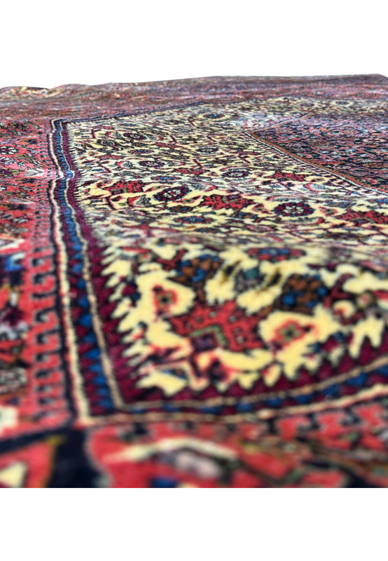 Another angle of the rolled Persian Bijar rug, emphasizing the tightness of the roll, the layering of patterns, and the play of colors that creates a three-dimensional effect in the textile
