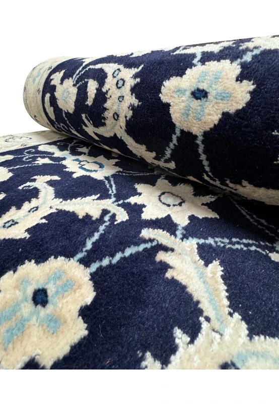 Close-up view of the Persian Nain Runner rolled up, illustrating the pattern continuity and rug thickness.