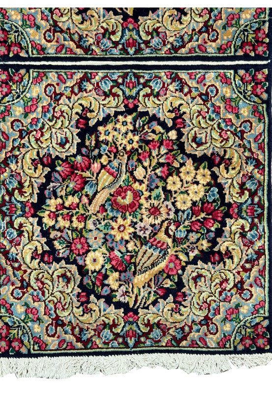 Close-up of a Persian Kerman rug's weave, revealing the high density of knots and color precision