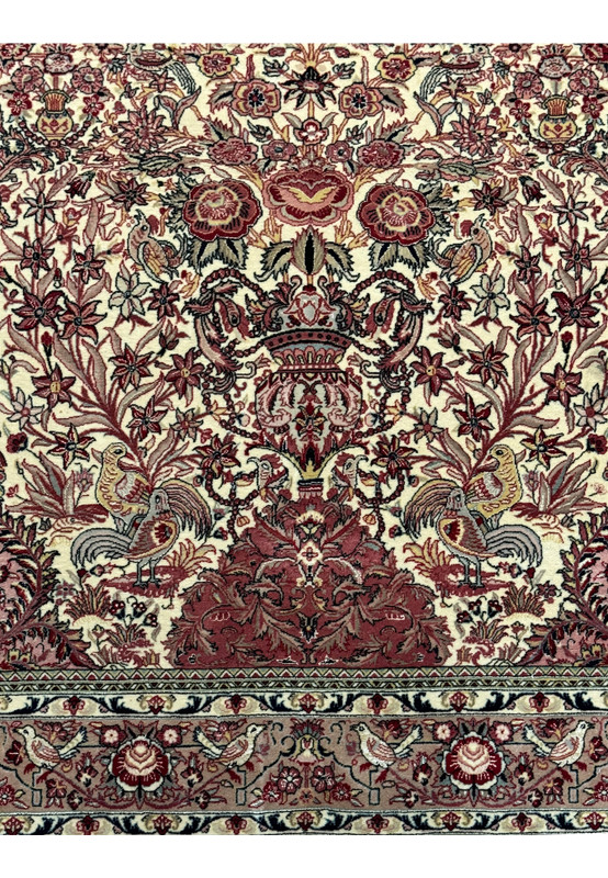 Close-up view showcasing the lower half of the Persian Qum rug, emphasizing the symmetry and rich colors of the floral designs and the fine craftsmanship of the weave.