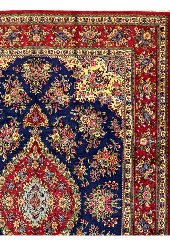 Detailed view of the corner of the Persian Qum Kork rug, highlighting the complex floral motifs and precise border patterns against the rug's navy blue background