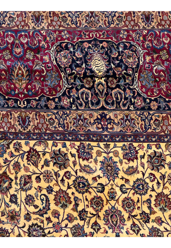 Close-up of the intricate patterns and vibrant colors in a Persian Mashad rug, featuring floral and vine motifs in red, blue, ivory, and gold, with detailed craftsmanship and traditional Persian design elements