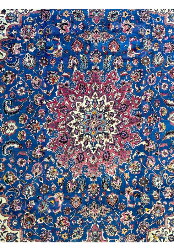 Detailed view of the central field of a Persian Mashad Rug, featuring a complex pattern of floral and vine motifs in navy blue and red
