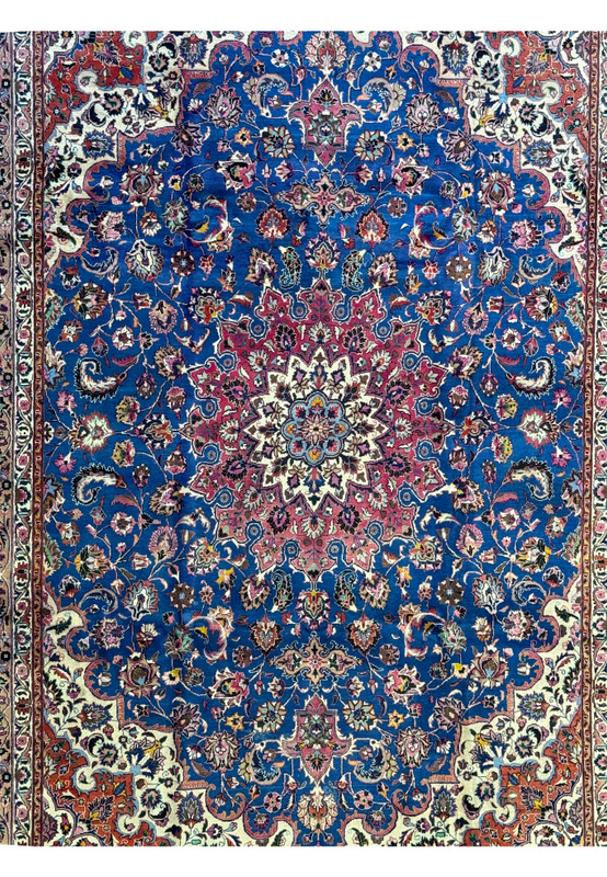 Close-up of the central medallion on a Persian Mashad Rug, highlighting intricate floral designs in crimson red, ivory, and navy blue