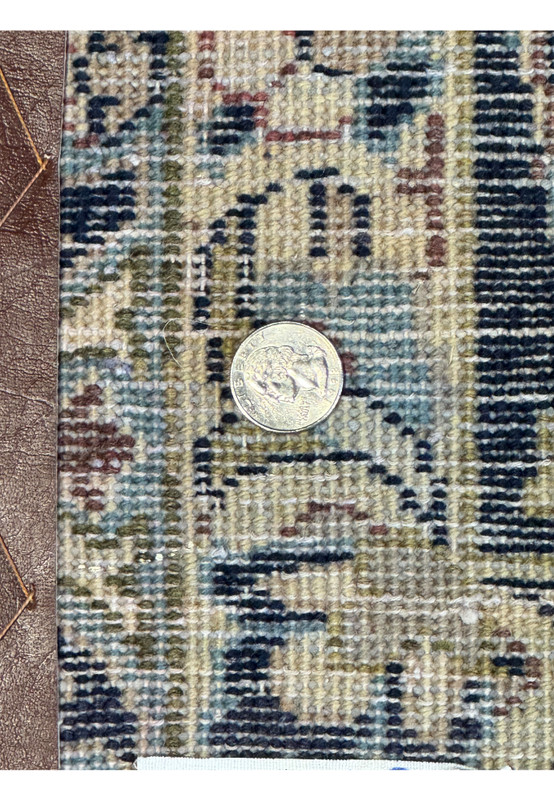 Detailed shot of the edge and fringe of a Persian Isfahan rug, displaying the precise hand-knotting and the elaborate floral motifs on the navy blue border against the rich red field