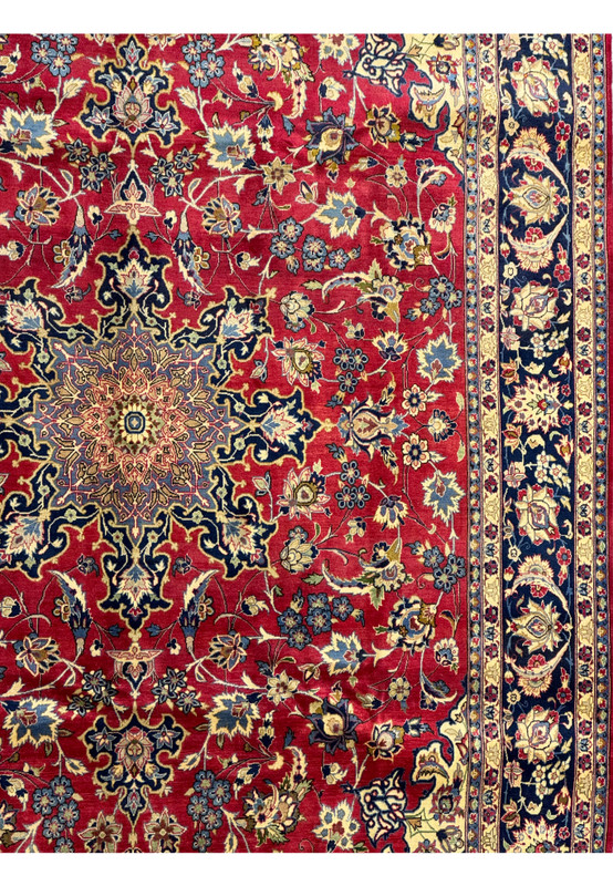 Midsection view of a Persian Isfahan rug, displaying the floral and arabesque designs on the red field.