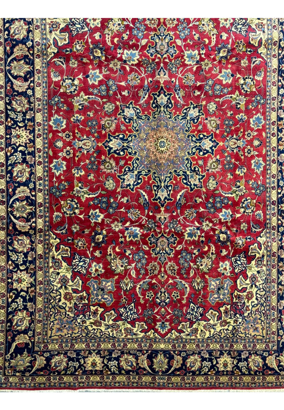 Detailed image of the border of a Persian Isfahan rug, highlighting the floral motifs in navy, gold, and red