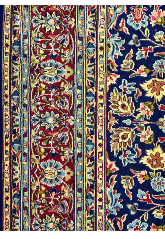 Detailed view of the lower right corner of a Persian Kerman Rug, showing the fine craftsmanship and the intricate design of the floral patterns.