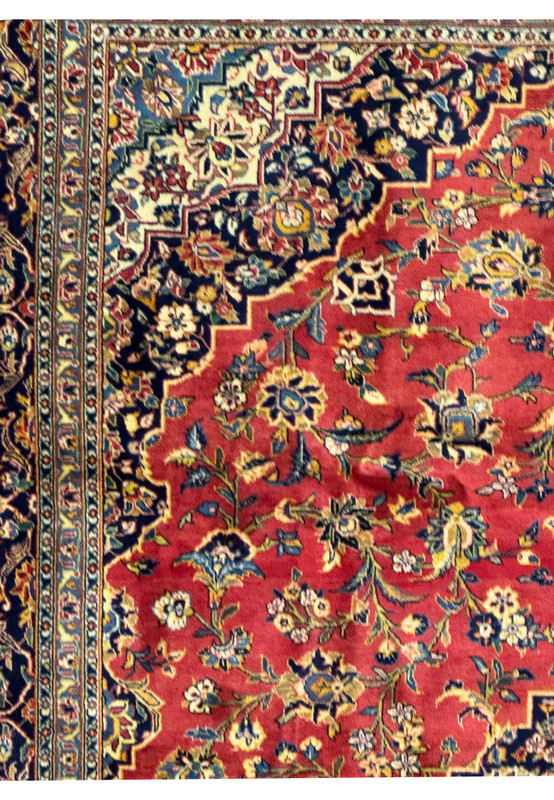 Full overhead view of a 9'2" x 12'5" Persian Kashan rug, laid out flat to display its complete design. The rug features a central medallion and floral motifs set against a vibrant red background, surrounded by an ornate border. The harmonious color palette of blues, golds, and ivory enhances the rug's elegance and sophistication. This image showcases the overall beauty and intricate craftsmanship of this high-quality Persian rug.