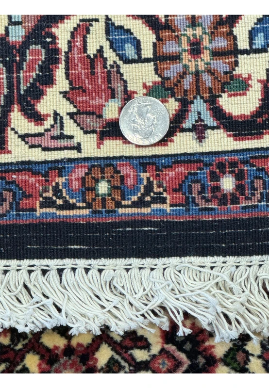 Back of the Persian Bijar Rug with a coin for scale, showing the dense weave and high-quality construction.