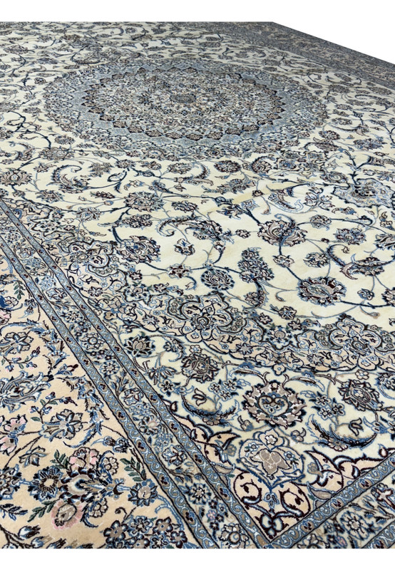 Close-up of the corner section showing intricate floral patterns and border of a Persian Nain 9LAA Wool & Silk Rug.