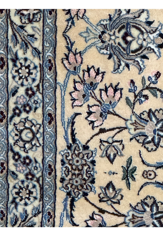 Close-up of the intricate floral patterns on a Persian Nain 9LAA Wool & Silk Rug.