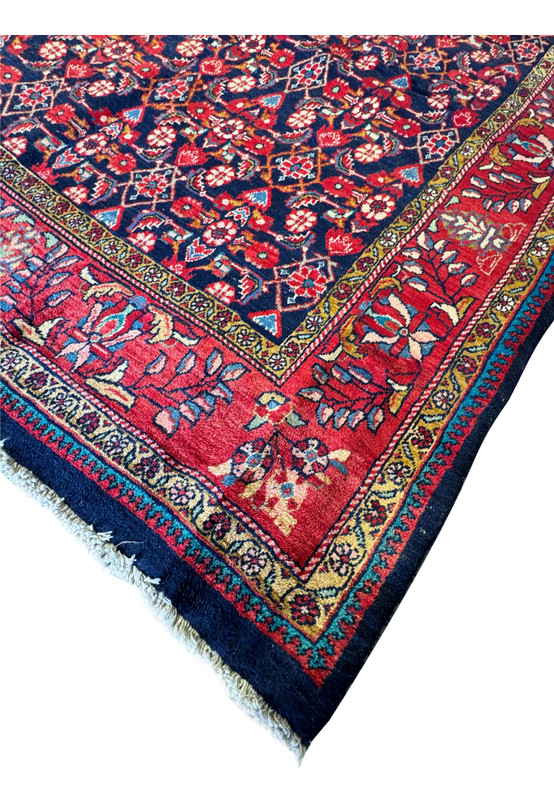 Corner detail of this Mahal 9x12 Persian Rug showing the deep red corner and navy blue central field