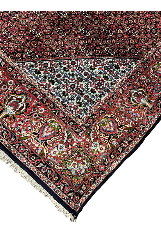 Edge detail of a Persian Bijar rug showing thick wool pile, reinforced selvage, dark navy edge finish, and strong construction known as the iron rug of Iran.