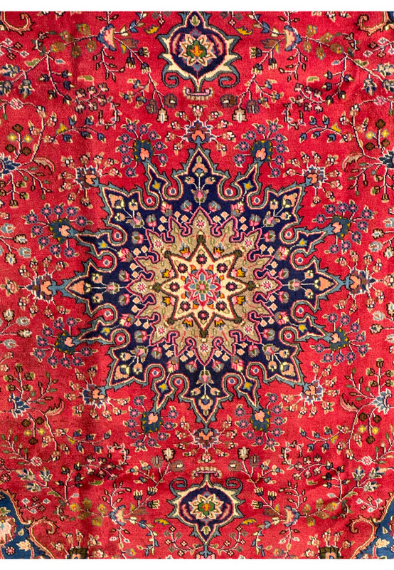 Detailed shot of the corner of the Persian Mashad rug, displaying the rich colors and intricate designs.