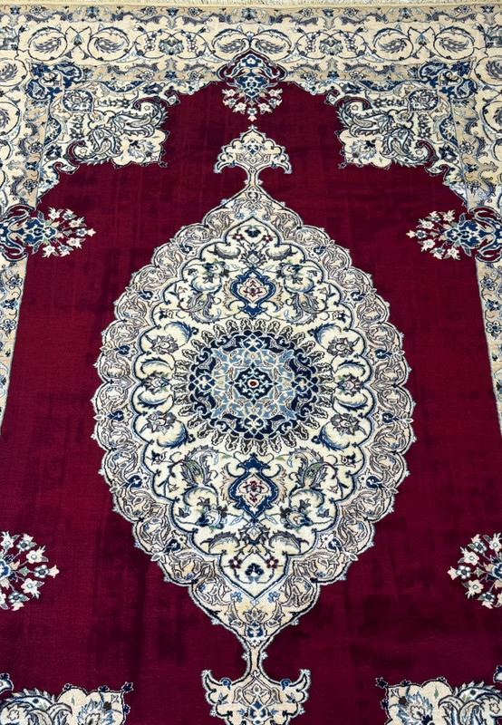 Midfield view of the 6'8 x 10'4 Persian Nain 9LAA Wool & Silk Rug, highlighting the detailed floral and vine patterns.