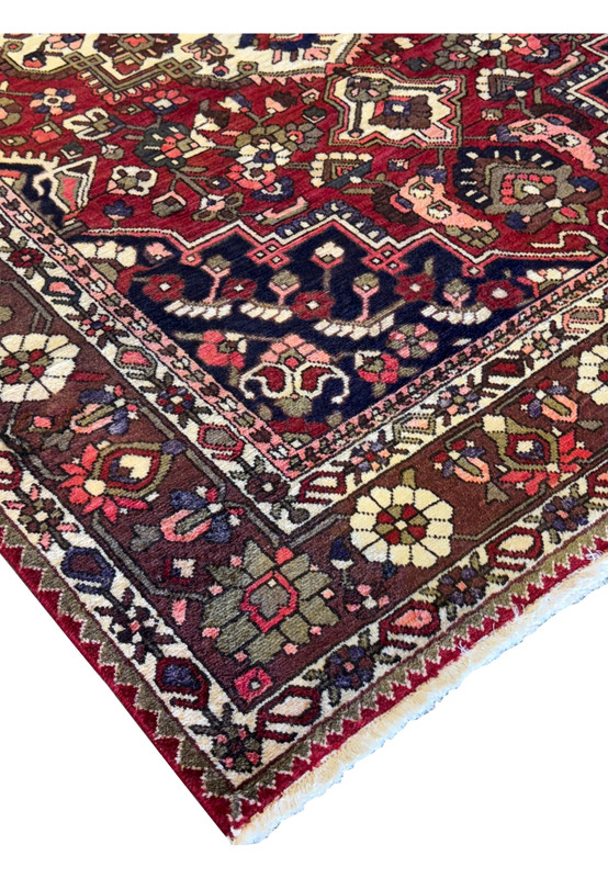 Detailed view of a section of the 6'6" x 10' Persian Bakhtiar rug highlighting floral and geometric motifs in rich colors