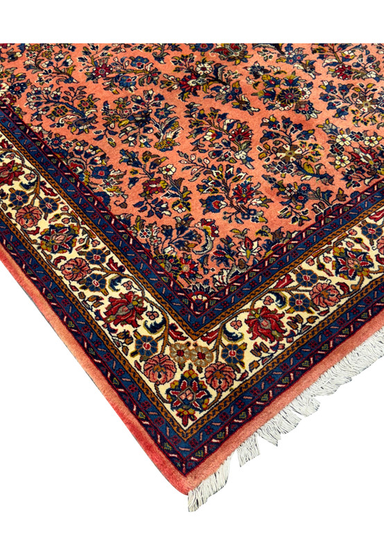 Corner detail of the 5'6" x 8'5" Persian Sarouk rug with fringe.