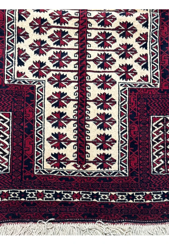 Detailed view of the border designs on a 3'1 x 4'2 Persian Baluch rug, showcasing zigzag and lattice patterns in red, blue, and ivory
