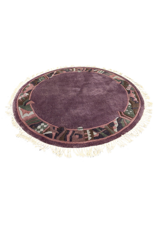 Side view of the 4'8 x 4'8 handmade round Nepalese rug laid flat, showcasing its plush wool texture and vibrant colors.