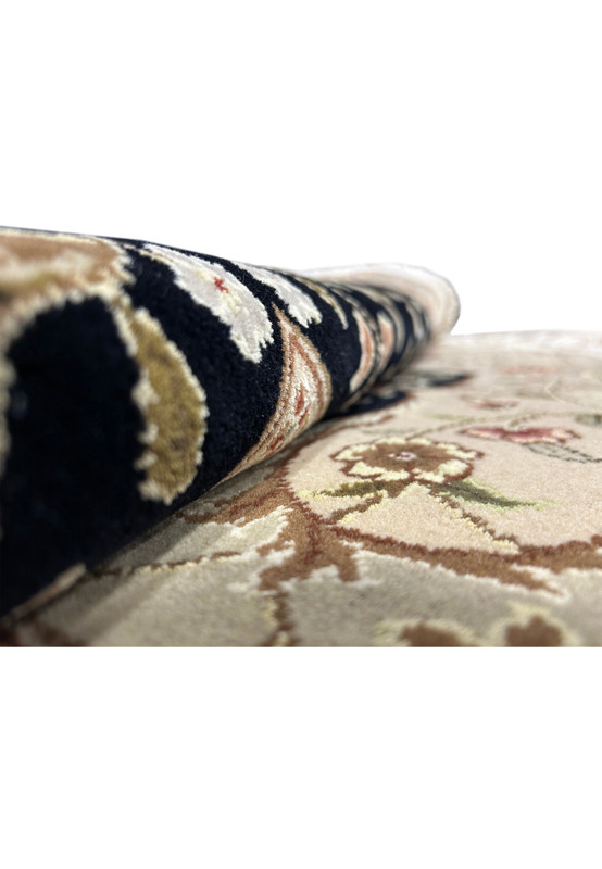 Rolled 12'5" x 18' Persian Tabriz Rug, focusing on the rug's edge to display the tight rolling and quality finish.