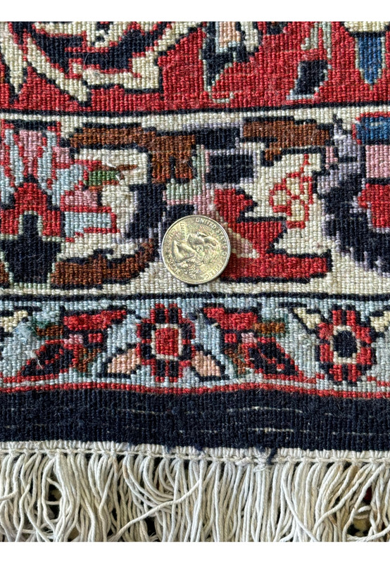 Close-up of the backside of a 9'10" x 13'1" Persian Bijar Rug with a coin demonstrating the fine weave quality