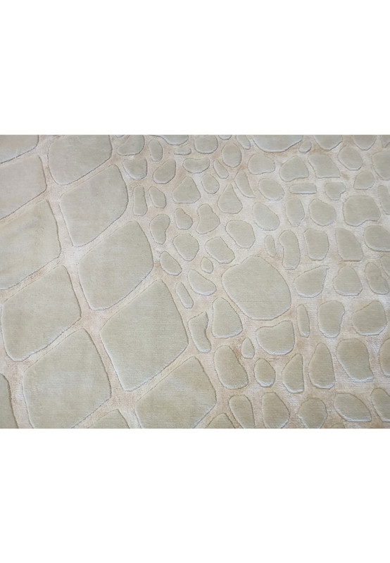 Close-up of the intricate cobblestone pattern on the modern handmade wool rug, featuring off-white tones and luxurious texture.