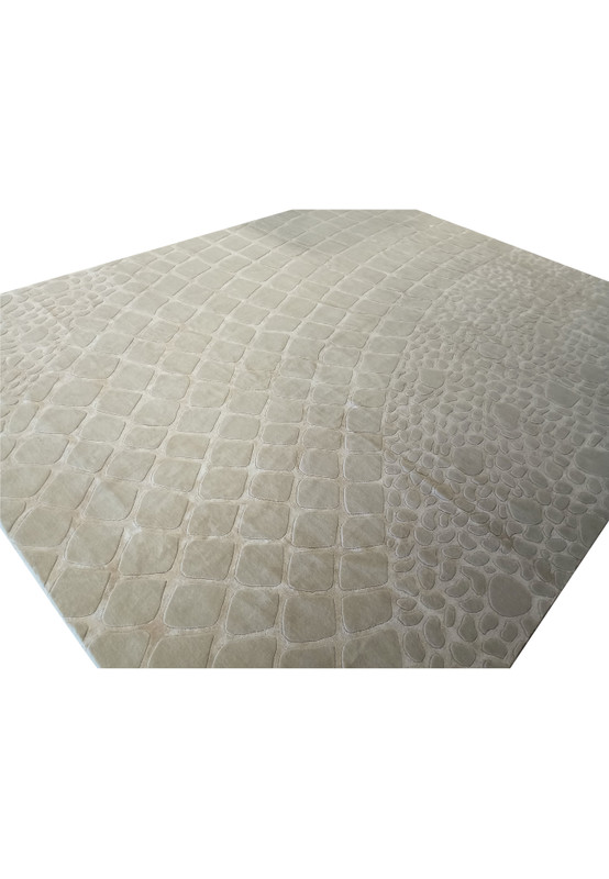Angled view of the 11' x 14' handmade wool rug, emphasizing the unique cobblestone pattern and modern design in off-white.
