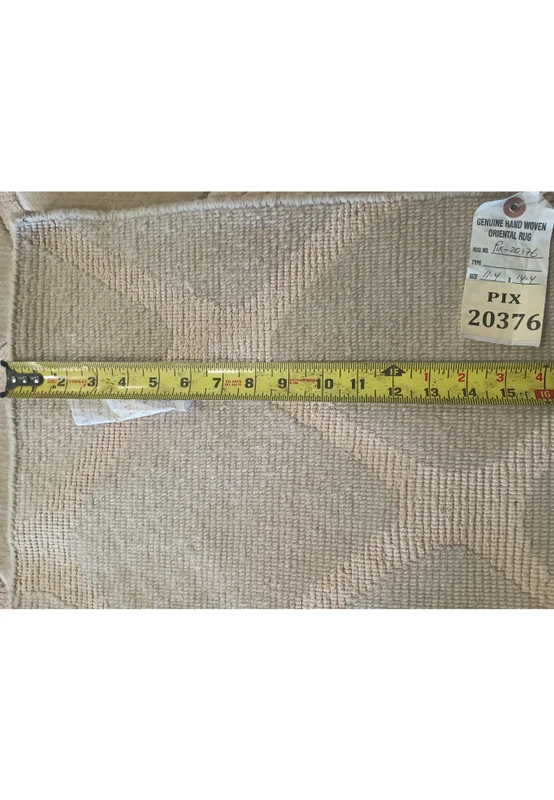 Zoomed-in view backside of the modern handmade rug's intricate cobblestone design, crafted in luxurious wool with a soft off-white color