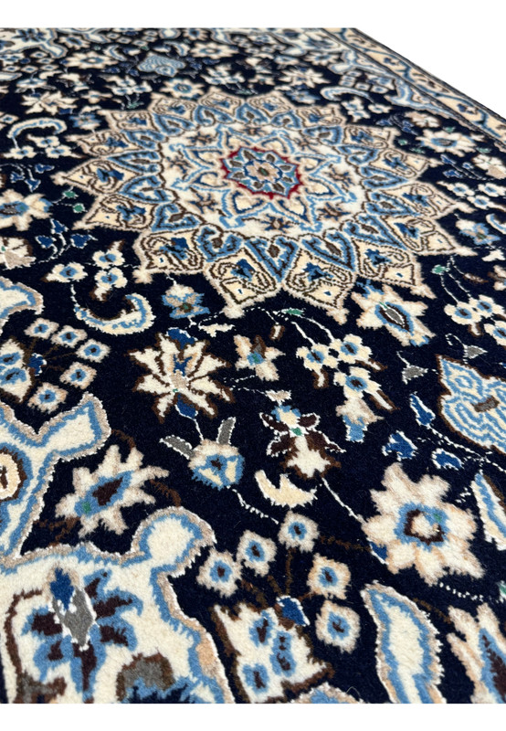 Angled view of a 2'8 x 4'6 Persian Nain Rug highlighting intricate wool weave and medallion design.