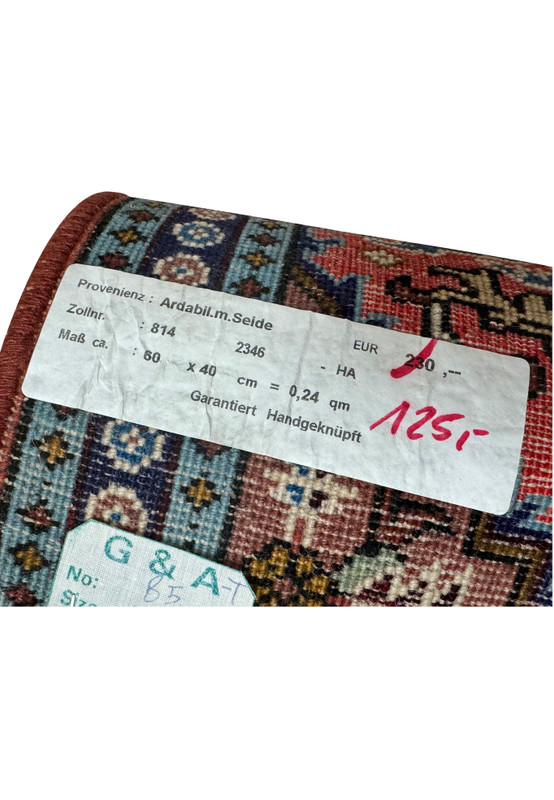 Tag on the 1'3 x 2 Persian Ardebil Wool & Silk Rug indicating origin and size.