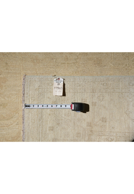 Backside of handmade Chobi rug showing fine weave detail, tag with item number, and measuring tape for scale.