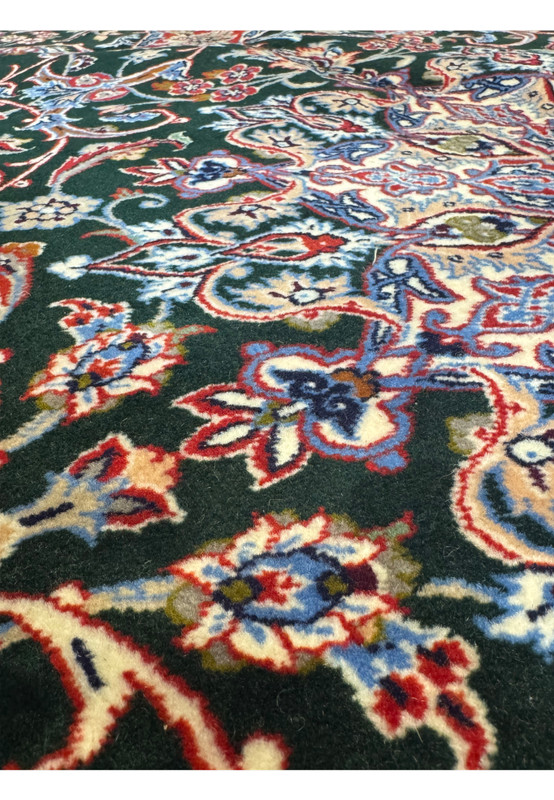 Perspective detail of Persian Isfahan Seirafian rug with flowing floral arabesques in hunter green, crimson, and ivory.
