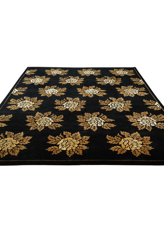 Top-down view of handmade modern floral rug with golden flowers on black background