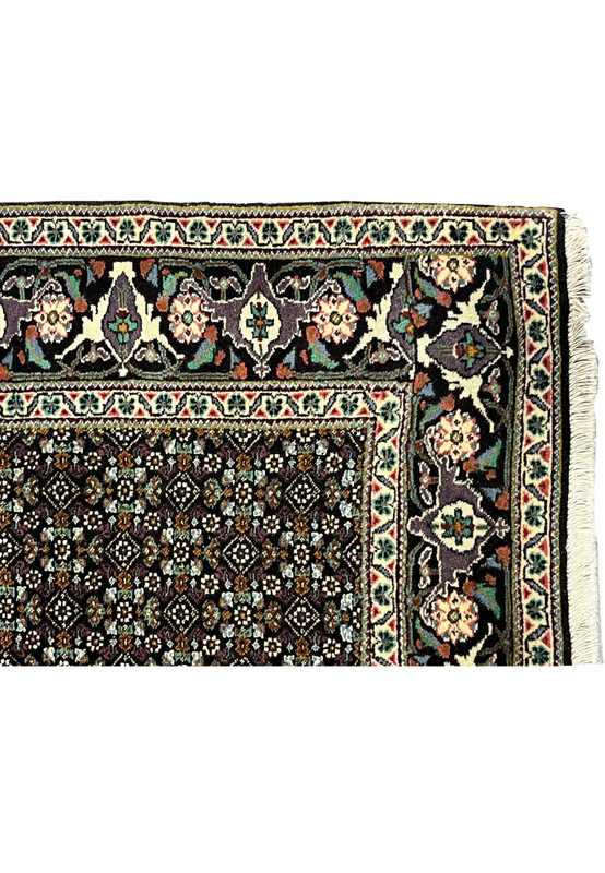 Lower corner of Persian Tabriz Mahi rug with ivory floral guard borders