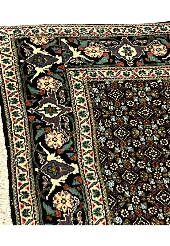 Upper floral border with palmettes and vines on Tabriz Mahi rug