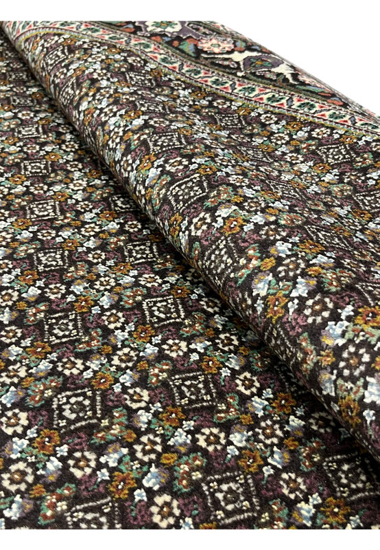 Rolled view of Persian Tabriz Mahi rug showing texture and weave density