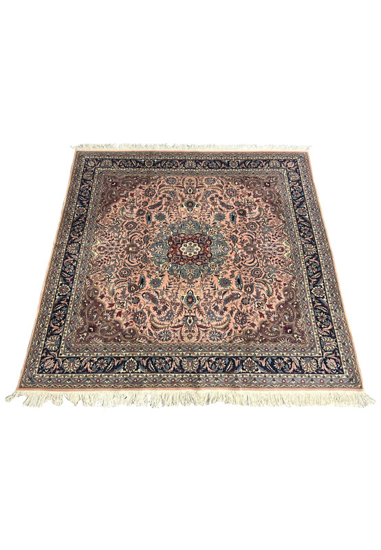 Laid-down view of Persian Tabriz square rug showing salmon background, navy border, and balanced floral motifs