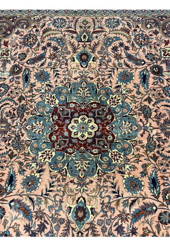 Center medallion of Persian Tabriz rug in burgundy, blue, and ivory tones surrounded by floral details