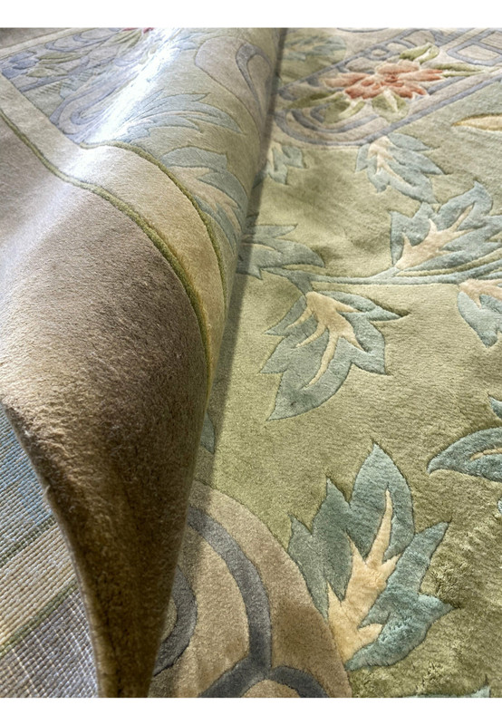 Rolled view of the rug revealing the plush wool pile and flexible backing, showcasing its supple construction, refined color harmony, and fine knot density characteristic of vintage Chinese craftsmanship.
