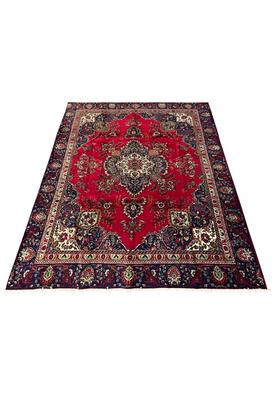 Hand-knotted 8'5" x 12'9" Persian Tabriz rug laid flat showing red floral field and detailed navy border