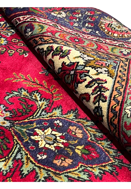 Rolled section of 8'5" x 12'9" Persian Tabriz rug showing soft wool texture and detailed weave