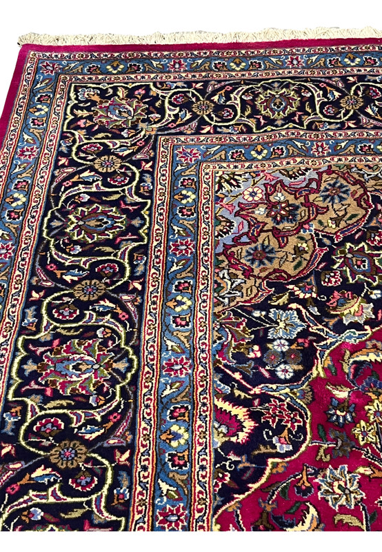 Border section of Persian Mashad rug with deep navy ground and scrolling floral pattern.