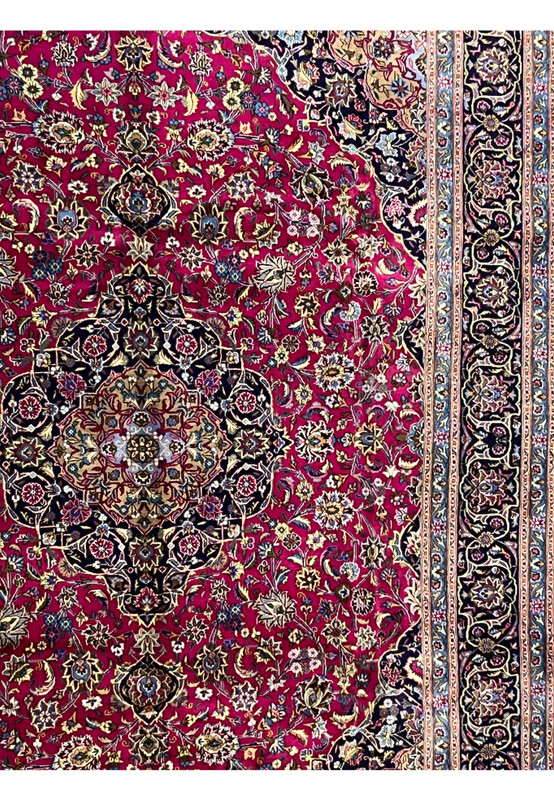 Side field detail of Mashad red rug showing floral designs and ivory highlights.