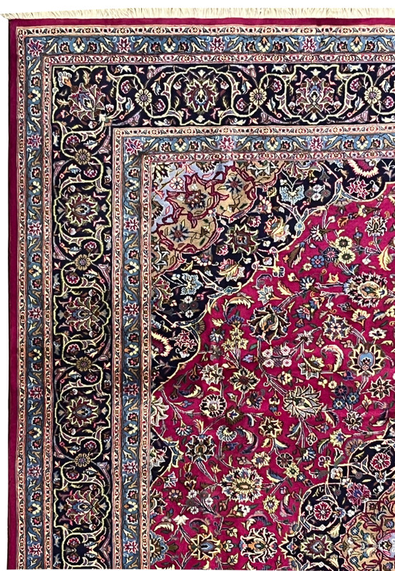 Upper border close-up of Persian Mashad rug with navy vines, sky blue accents, and floral scrolls.