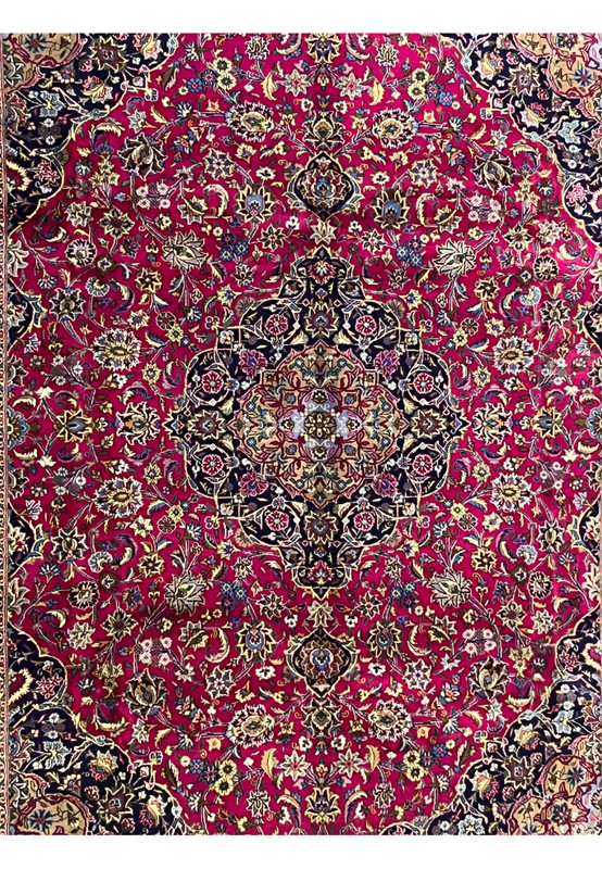 Central field close-up of Mashad rug highlighting ruby red background and intricate floral motifs.