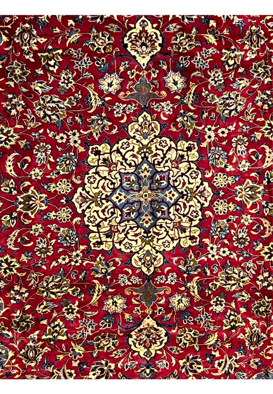 Closeup of 8'5 x 11'8 Persian Isfahan rug medallion with ivory, blue, and gold floral detailing.